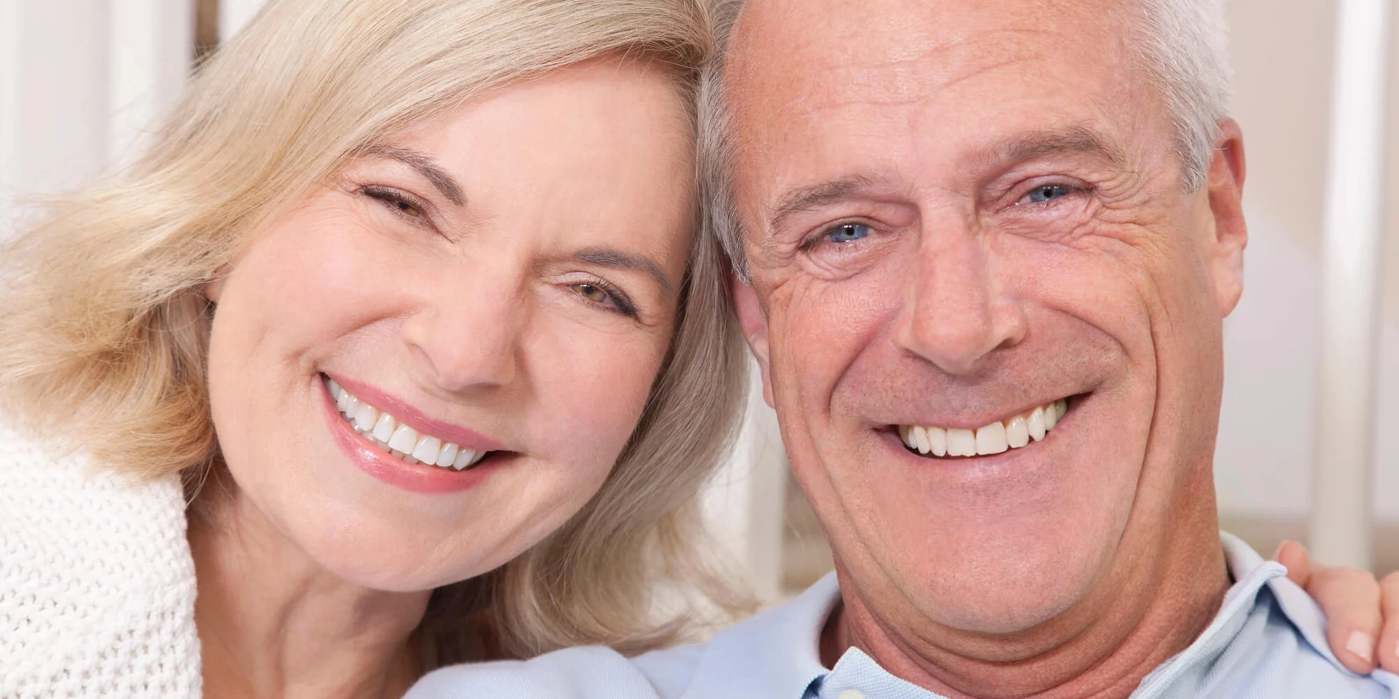 Couple smiling after getting dental crowns raleigh