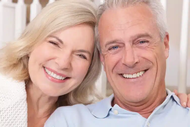 Couple smiling after getting dental crowns raleigh
