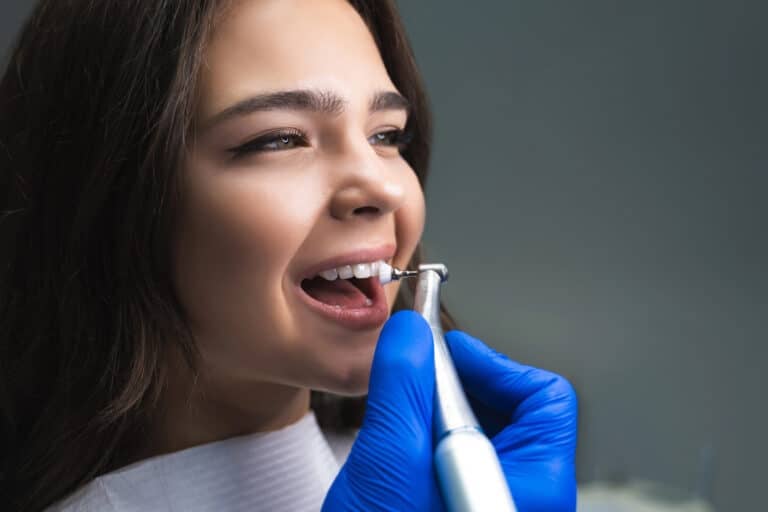 Girl cleaning her veneers raleigh nc