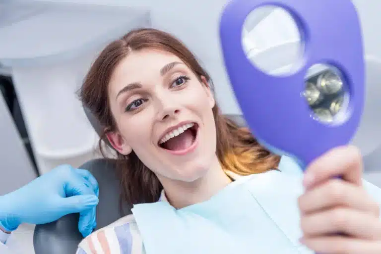 Woman smiling after oral surgery raleigh nc